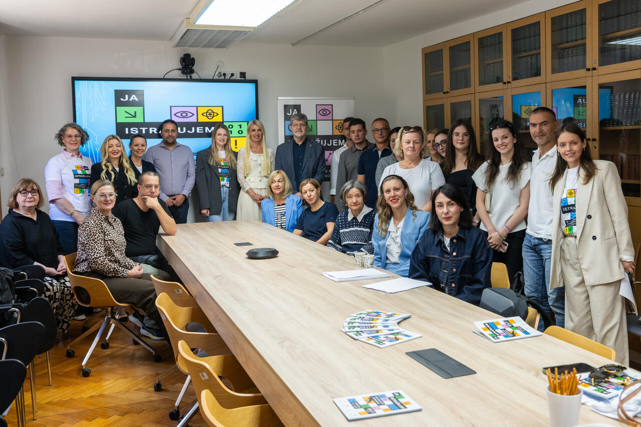 Group photo of project members and guests in the Council Chamber, with the "JA ISTRAŽUJEM" European Researchers’ Night logo on the screen.