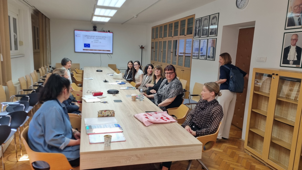 Članovi projektnog tima za stolom uz prezentaciju UMIP-a prikazanu na ekranu.